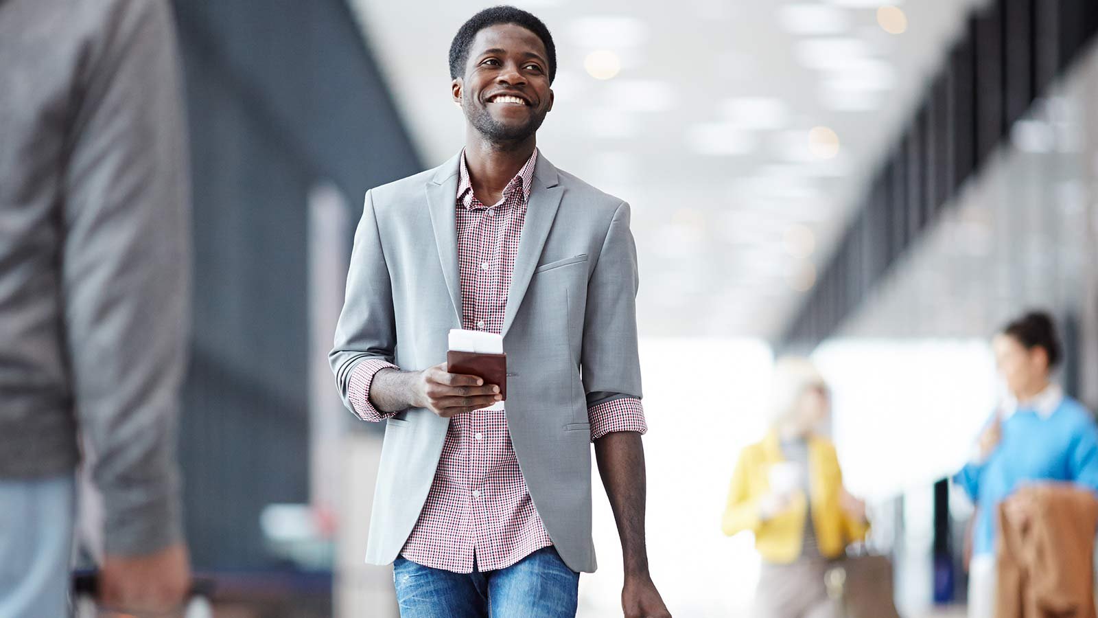 Man walking through airport holding passport