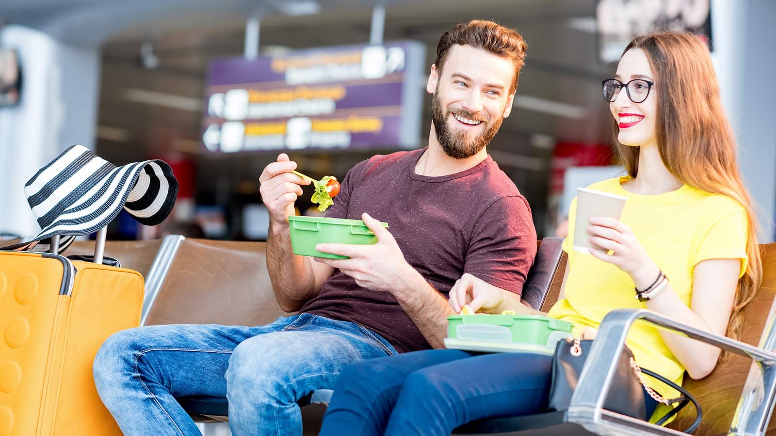 Couple eating salad in airport terminal